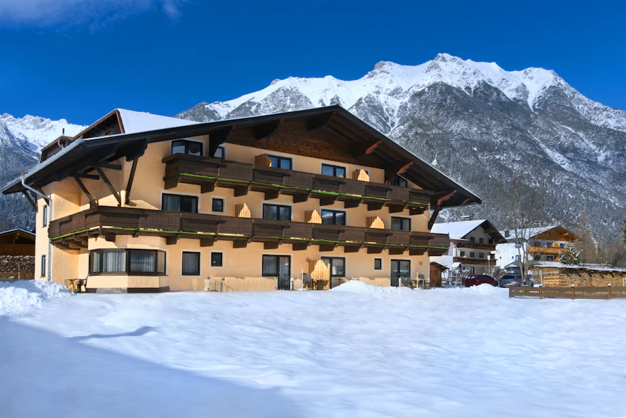 Albergo alpino con i balconi in legno, sotto la neve