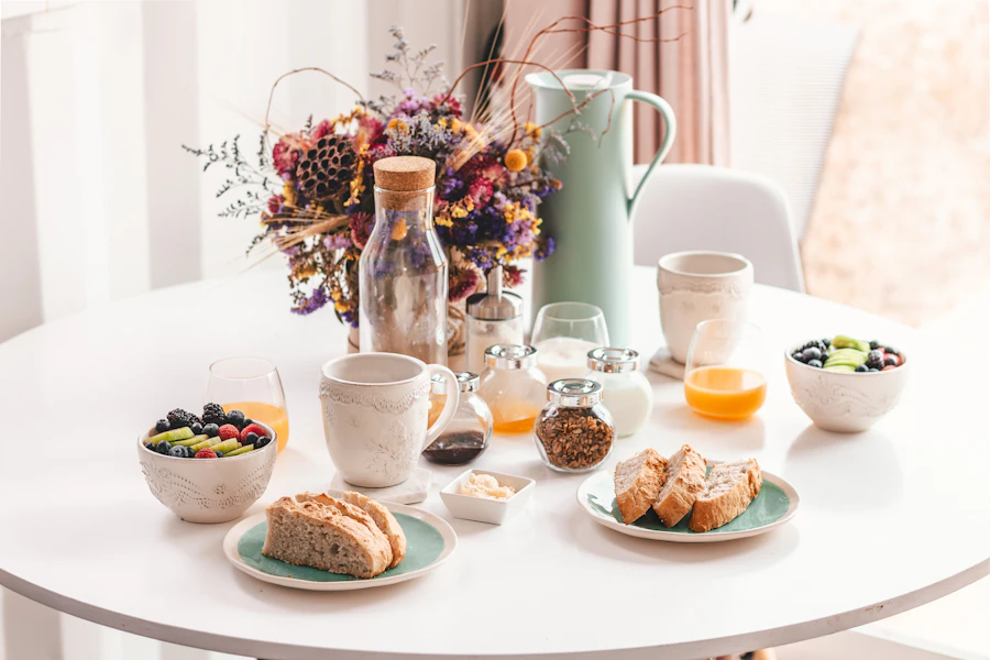 Tavolo della colazione con pane, frutta e fiori secchi