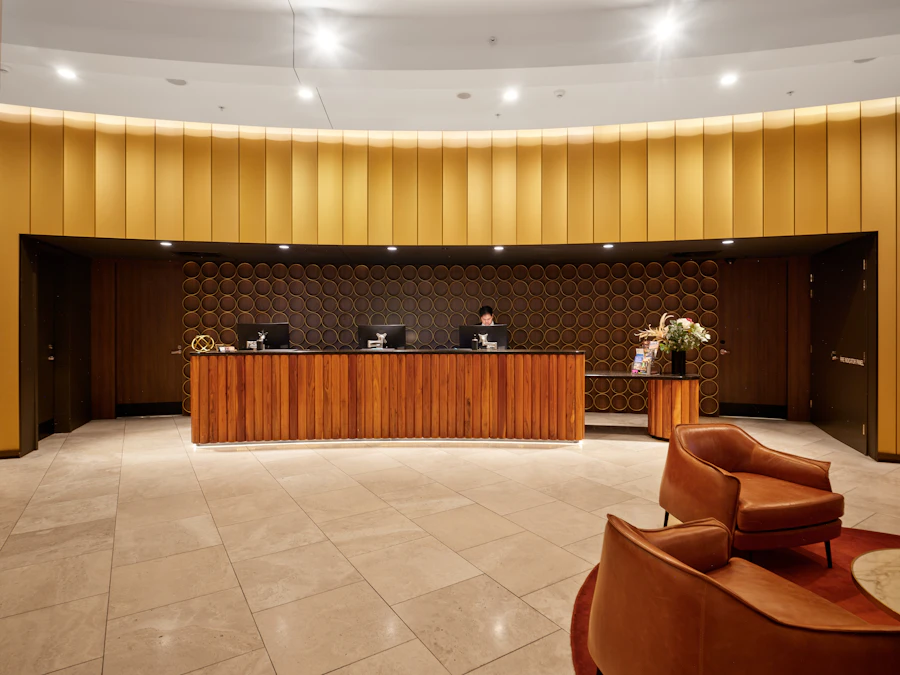 Reception con il bancone in legno e le poltrone in pelle
