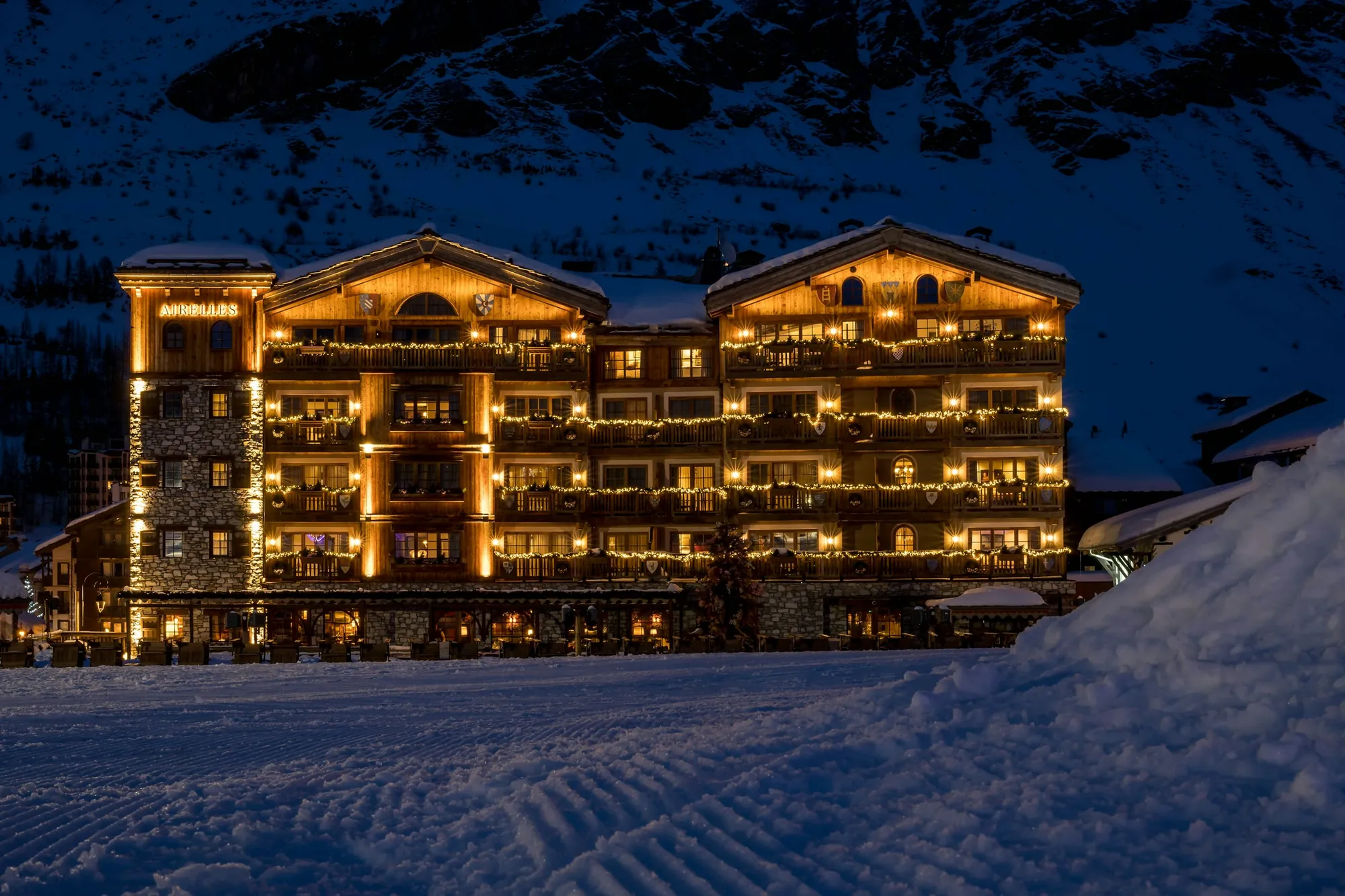 Albergo di montagna la sera, con tutte le finestre accese sulla neve
